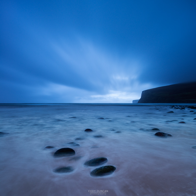 Clouds sweep across sky in fading light over beach at Rackwick Bay, Hoy, Orkney, Scotland