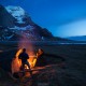 Two people enjoy campfire at Bunes Beach, Moskenesoy, Lofoten Islands, Norway